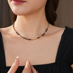 Detailed close-up of bohemian beaded necklace with natural stones and gold metal beads