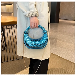 Detail of blue metallic crescent handbag with diamond texture and gold chain strap