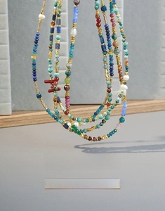 Close-up of bohemian beaded necklace featuring colorful natural stones and freshwater pearls