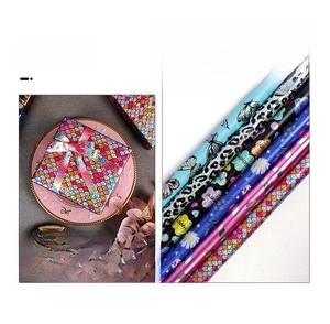 Detail of holographic laser wrapping paper roll with floral and fish scale patterns