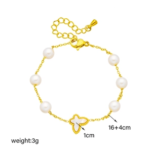 Elegant gold chain bracelet with white pearls and a clover shell pendant on white backdrop