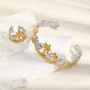 Detailed shot of gold and silver cutout bangle with starfish and seashell patterns