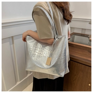 Detail of silver crocodile pattern tote bag with shoulder strap and glossy finish