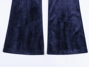 Detail of navy blue velvet flared trousers hem showing soft fabric texture and wide leg cut