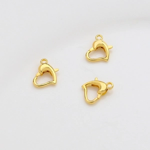 Detailed macro shot of three 14k gold-plated heart-shaped lobster clasps for jewelry