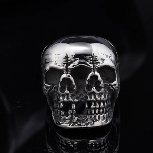 Macro detail of gothic punk ring featuring three-sided skull design in polished steel