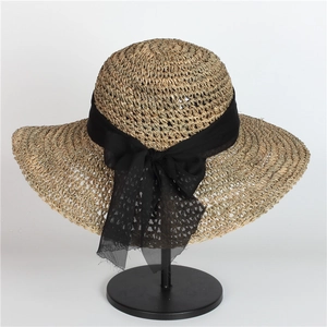 Elegant wide-brim straw hat with black bow ribbon and foldable sun protection design