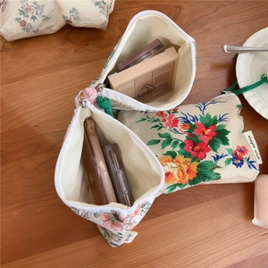 Detailed macro view of floral cotton storage bags for cosmetics on a wooden table