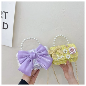 Détail de mini sac en tweed pour enfant avec poignée en perles et nœud violet et jaune