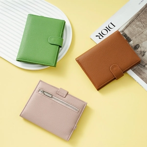 Detailed view of pebbled leather passport wallets in green, brown, and pink with snap button
