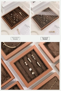 Detail view of brown velvet jewelry display trays with transparent lids for rings