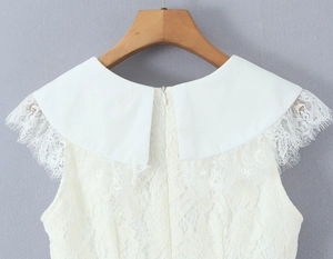 Close-up of white lace dress featuring a V-neckline with delicate embroidery detail