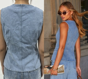 Détail du gilet en jean bleu clair montrant les coutures et la coupe ajustée