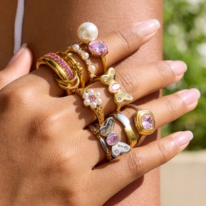 Stackable gold and silver rings with pink zircon, butterfly, and pearl accents