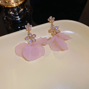 Macro detail of pink floral earrings with sparkling rhinestones and gold base
