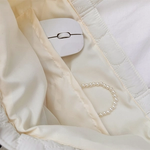 Interior detail of quilted tote bag featuring two functional slip pockets and white lining