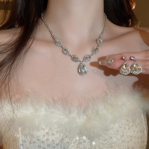 Close-up of sparkling teardrop rhinestone necklace and earring set on a model