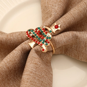 Rond de serviette sapin de Noël doré avec strass colorés sur une serviette en lin brun