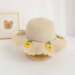 Dettaglio cappello di paglia per bambini con girasole e bordi a conchiglia