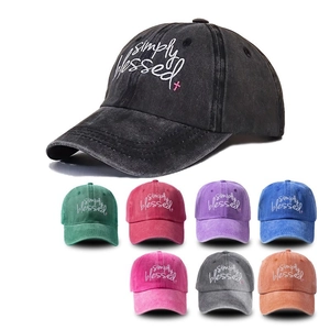 Detailed view of embroidered baseball caps in multiple colors and washed cotton material