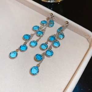 Dettaglio orecchini a frangia lunga placcati oro 18k con perle in vetro blu chiaro