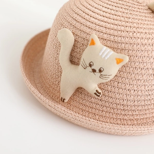 Close-up of fine woven straw texture and cute cartoon cat fabric patch on kids sun hat