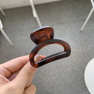 Detail of a brown tortoise shell hair claw clip with a glossy acetate resin finish