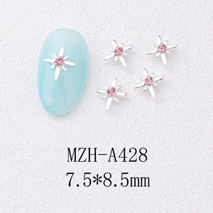 Macro view of 7.5x8.5mm star-shaped nail charms with pink rhinestones on silver metal