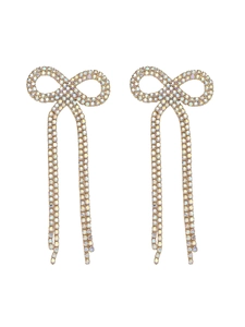 Close-up of golden bow tassel earrings with sparkling iridescent rhinestones on white
