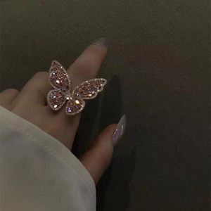 Macro shot of a butterfly ring with pink zircon crystals on a model's finger