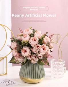 Pink artificial peonies in a green ribbed ceramic vase for elegant home decor