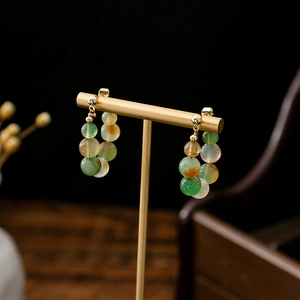 Macro shot of traditional beaded ring earrings with gold metal accents on a black background