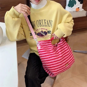 Detailed view of a stylish pink and red striped plush shoulder bag for autumn and winter