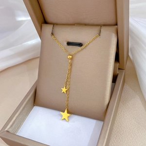 Minimalist gold titanium steel tassel star necklace displayed in a premium jewelry box