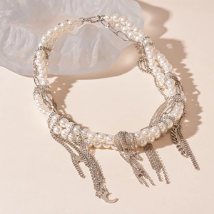 Detailed view of layered faux pearl necklace with star and moon tassel charms