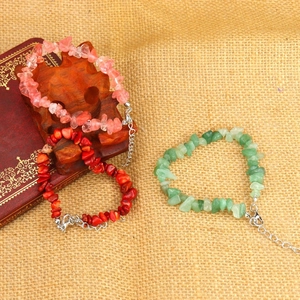Detail of adjustable natural crystal stone bracelets in pink, red, and green with silver chain