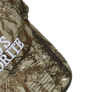 Detailed close-up of 3D white embroidery and camo twill fabric on vintage baseball cap
