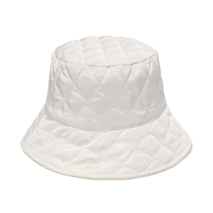 Détail du chapeau bob matelassé blanc avec motifs de losanges et bordure polaire
