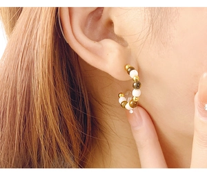 Close-up of C-shaped S925 silver earrings with brown tiger eye beads on female model