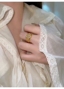Vue détaillée d'une bague fleur dorée vintage avec zircon sur la main du mannequin