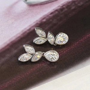 Elegant leaf-shaped earrings with clear marquise stones on a velvet background