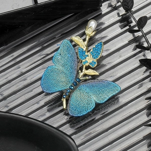 Elegant butterfly pearl brooch with blue embroidery and gold metallic accents