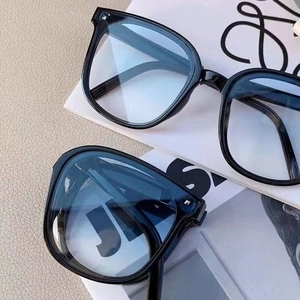 Macro shot of stylish black foldable sunglasses layered on a fashion magazine background