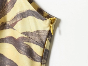 Detail of zebra print sleeveless dress featuring high-quality concealed back zipper closure