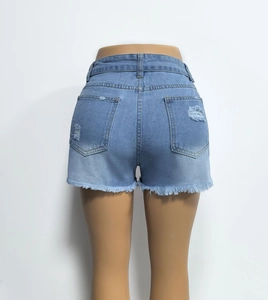 Rear view of distressed light blue denim shorts with frayed hem and ripped back pocket