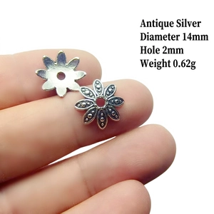 Macro detail of antique silver flower bead caps with 14mm diameter and 2mm hole