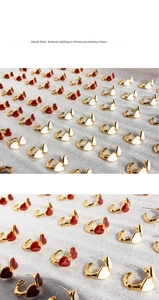 Detailed close-up of vintage enamel heart stud earrings in red and white color variants