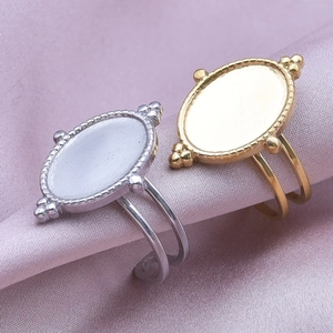 Macro shot of gold and silver oval DIY ring blanks on elegant lavender silk fabric