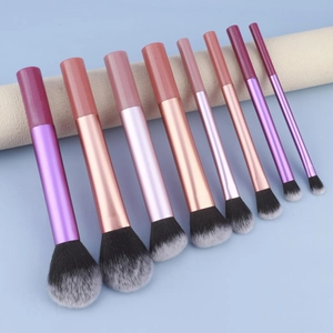 Eight piece purple makeup brush set with gradient bristles on beige display stand