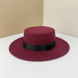 Classic burgundy wool boater hat with black ribbon band on a minimalist background